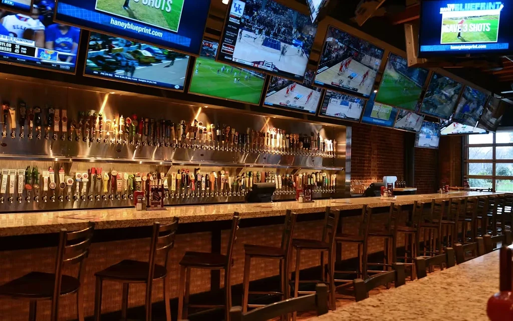 Long bar with dozens of beer taps and multiple sports TVs.