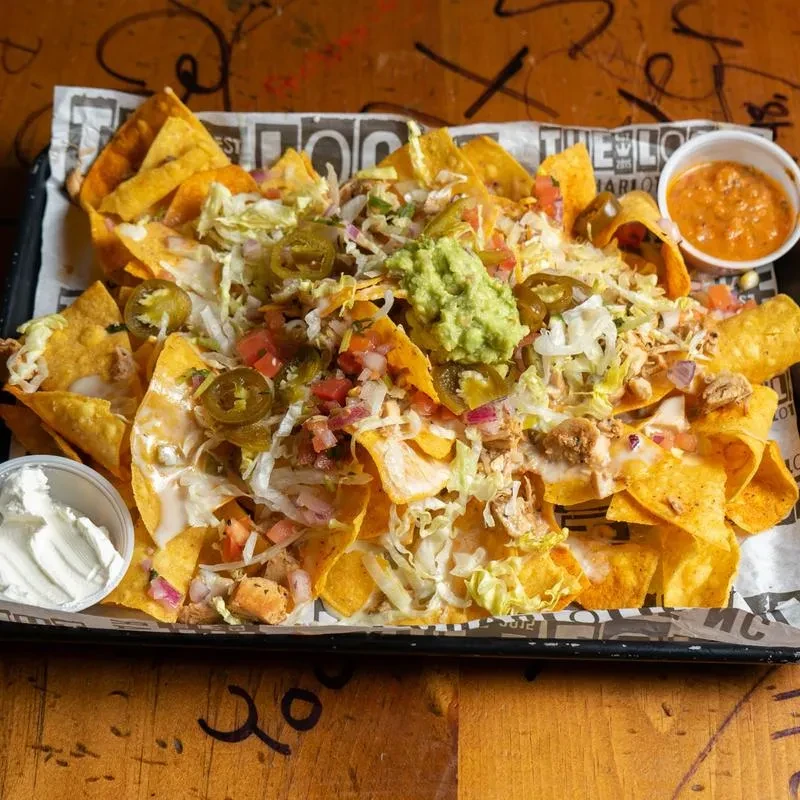 Generous loaded nachos with chicken, guacamole, sour cream, and cheese sauce.