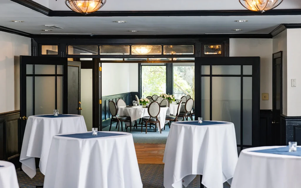 Elegant restaurant with cocktail tables leading to a formal dining room.