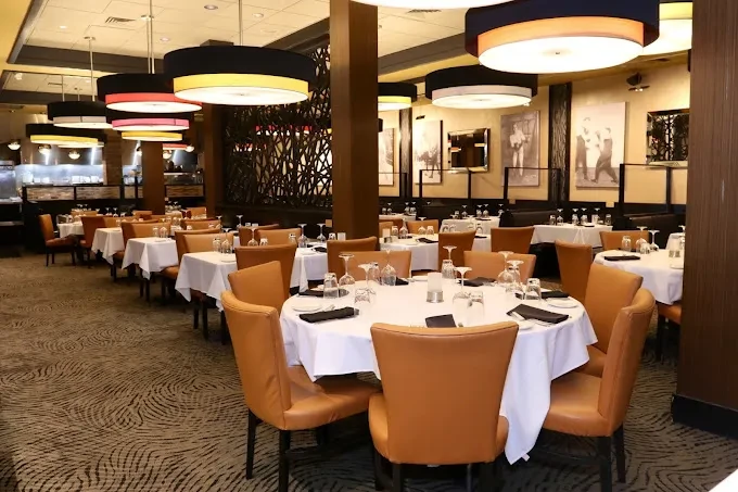Empty upscale restaurant interior with set tables and modern lights.