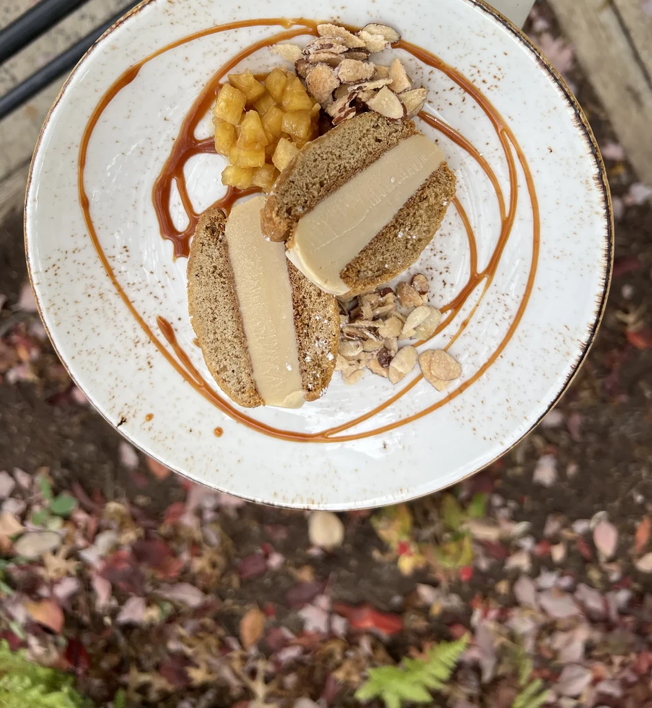 Cream-filled cake slices with fruit, almonds, caramel, on autumn leaves.