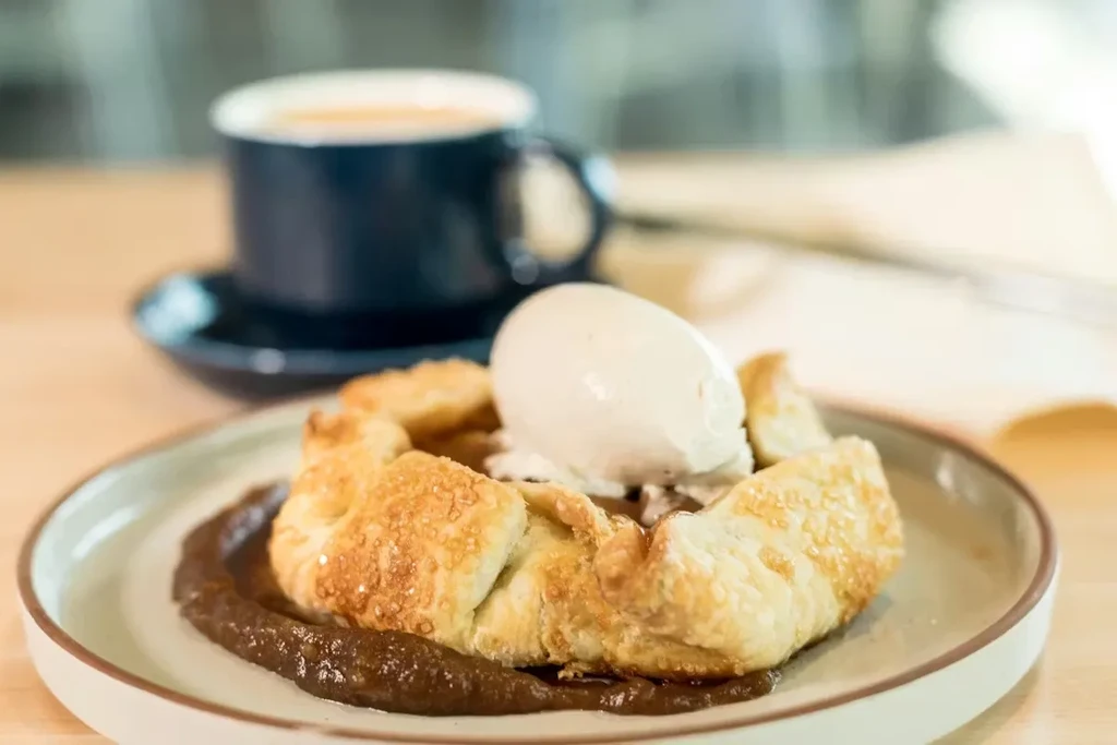 Golden-brown galette topped with ice cream and dark sauce.