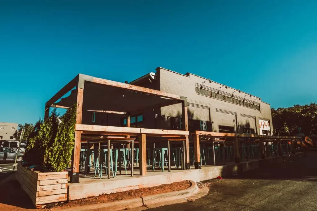 Heist Brewery's brick building exterior and modern outdoor patio.