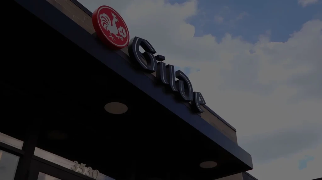 Gus's metallic sign on a dark awning with a red rooster logo.