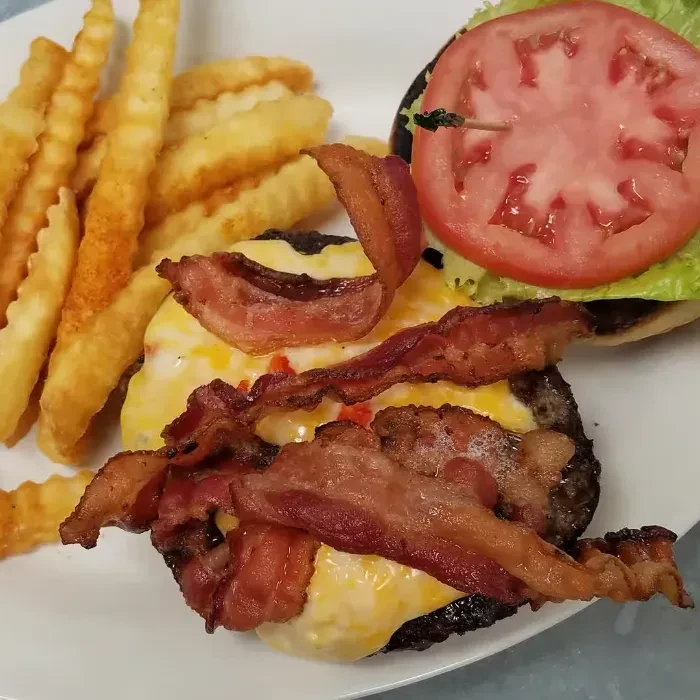 Open-faced cheeseburger with bacon, lettuce, tomato, and crinkle-cut fries.