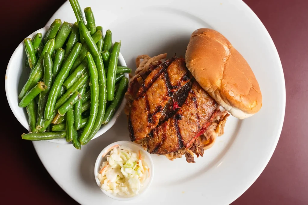 Top-down view of a BBQ sandwich meal with sides.