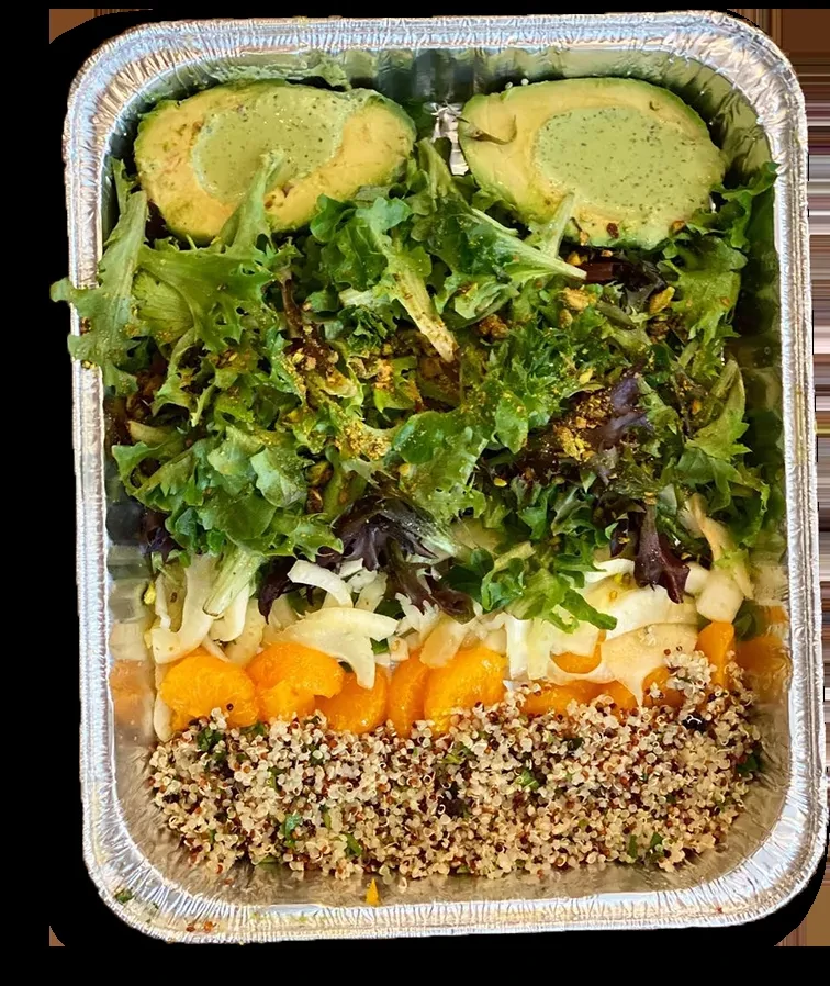 Vibrant layered salad with quinoa, oranges, greens, and avocado in a foil tray.
