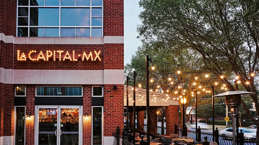 LA CAPITAL MX restaurant building with a lit marquee and outdoor patio.