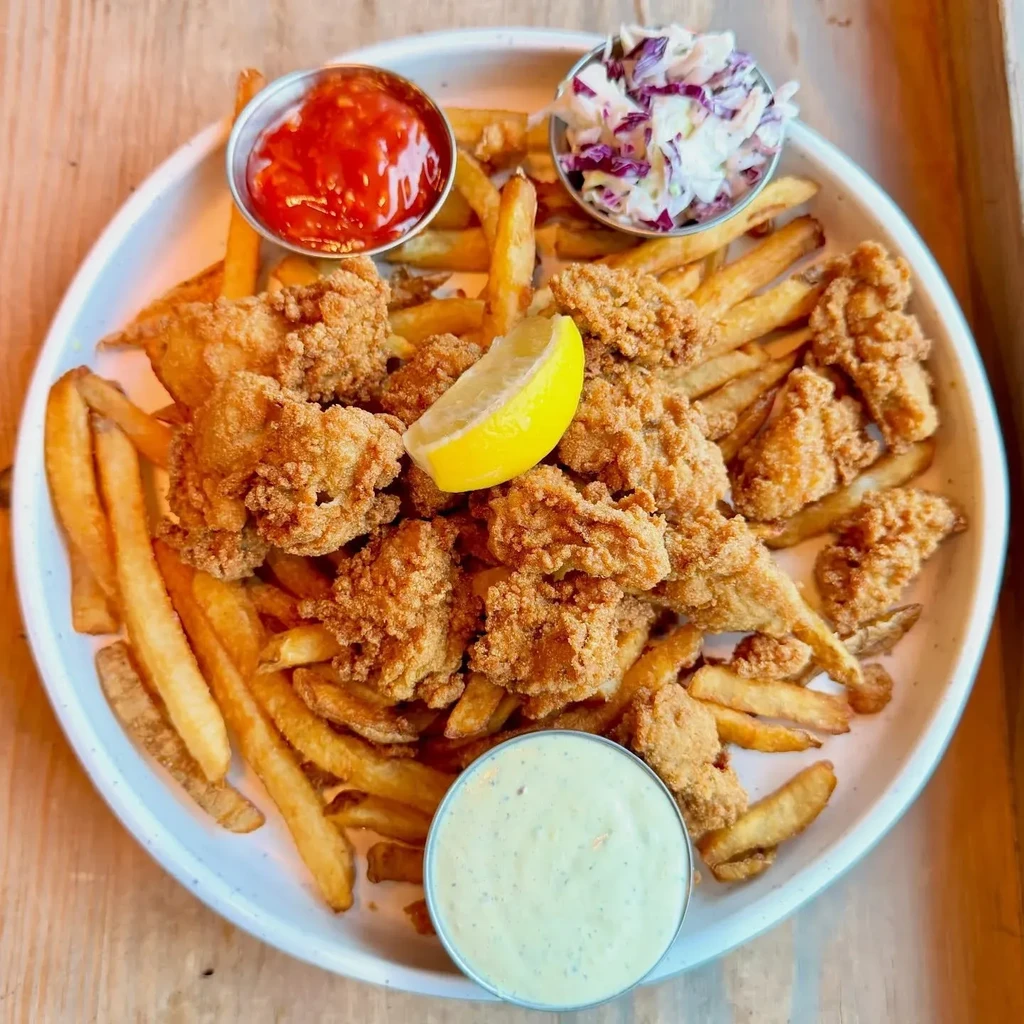 Crispy fried seafood and fries with lemon, coleslaw, and dipping sauces.