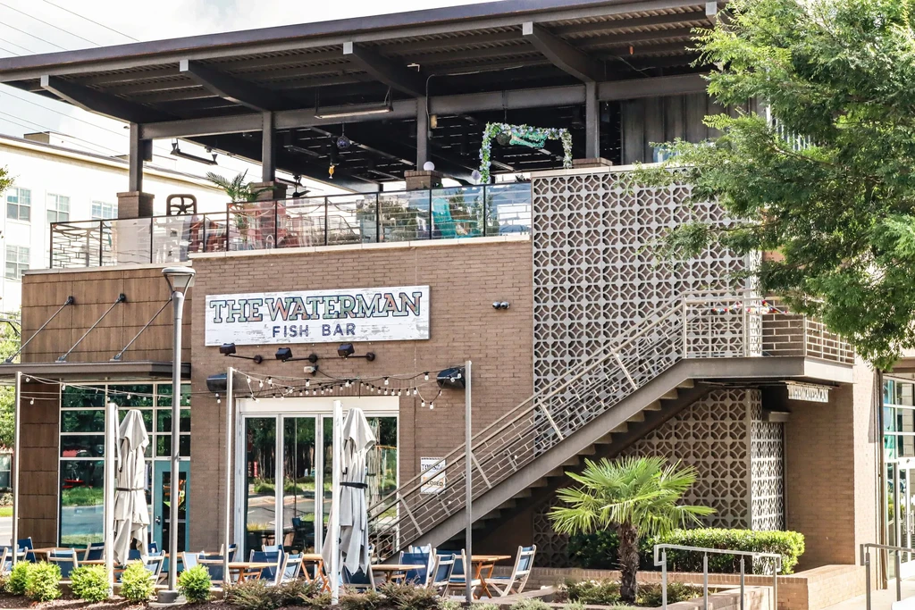 Waterman Fish Bar building: brick facade, ground patio, rooftop bar.