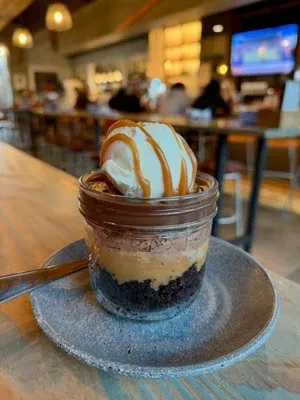 Layered dessert jar topped with vanilla ice cream and caramel.