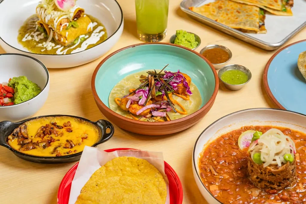Mexican spread with enchiladas, fried taco, queso fundido, and bean stew.