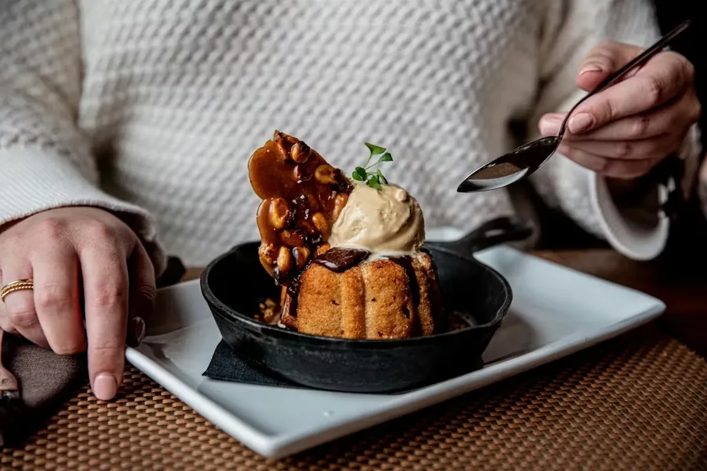Skillet cake with ice cream, chocolate, brittle, and a poised spoon.