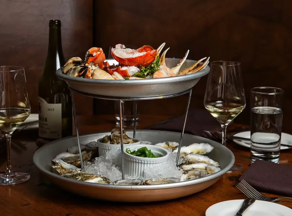 Lavish two-tiered seafood tower with lobster, crab claws, and oysters.
