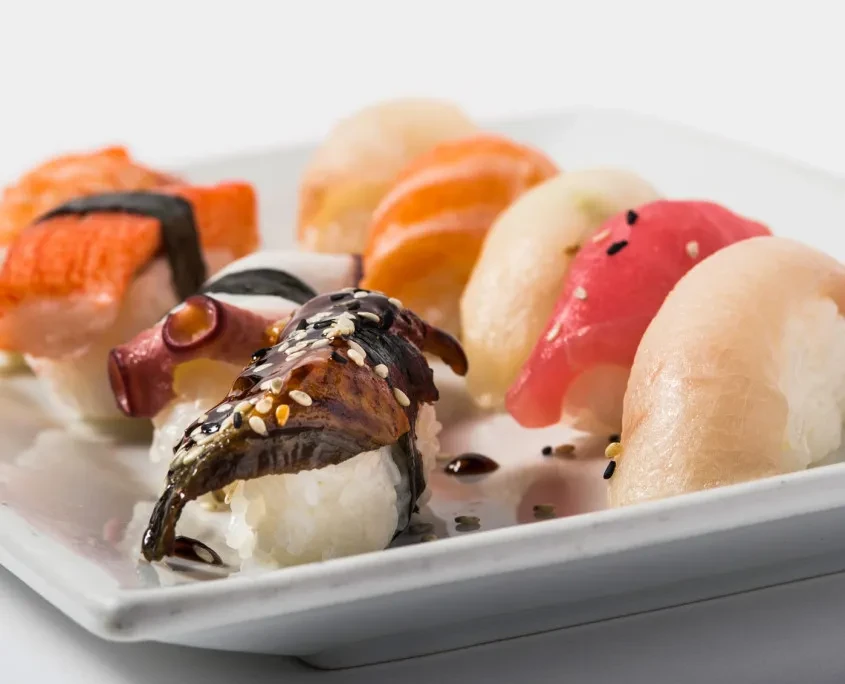 Colorful nigiri sushi assortment featuring eel, tuna, and salmon.