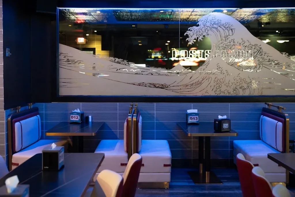 Blue-lit modern restaurant interior with frosted ocean wave glass and booths.