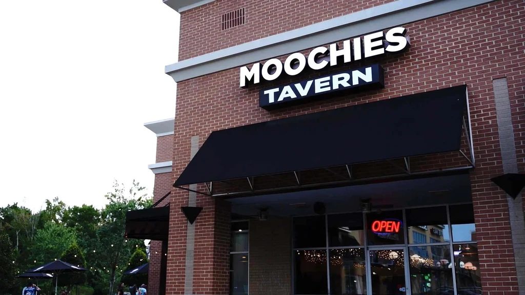 Moochies Tavern brick building exterior, 'OPEN' sign, and outdoor patio.