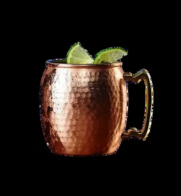 Hammered copper mug with two lime wedges on black background.