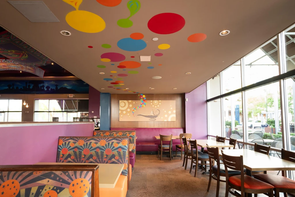 Vibrant, eclectic restaurant interior with patterned booths and whimsical decor.