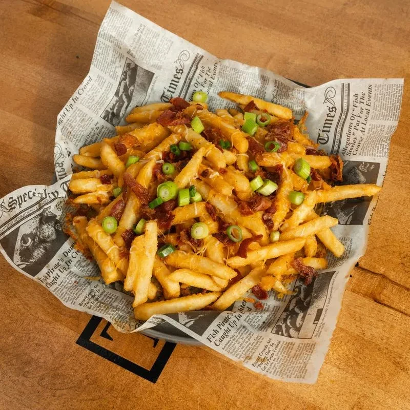 Loaded fries with melted cheese, crispy bacon, and green onions.
