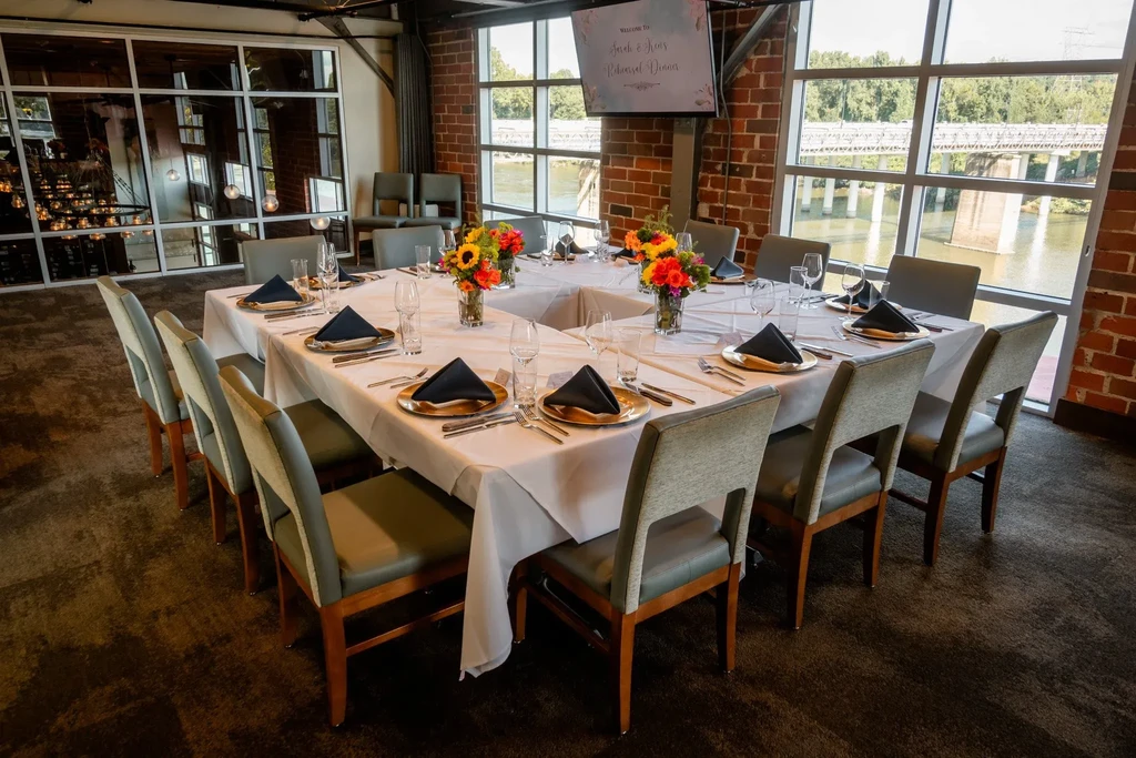 U-shaped table set for Sarah & John's Rehearsal Dinner, with sunflowers.
