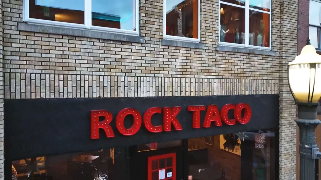 ROCK TACO restaurant storefront, brick building, red illuminated sign.