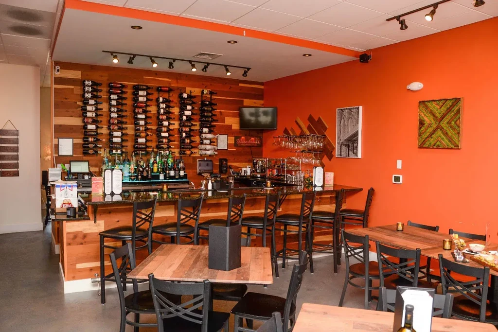 Clean, well-lit modern restaurant bar with wine and liquor displays.
