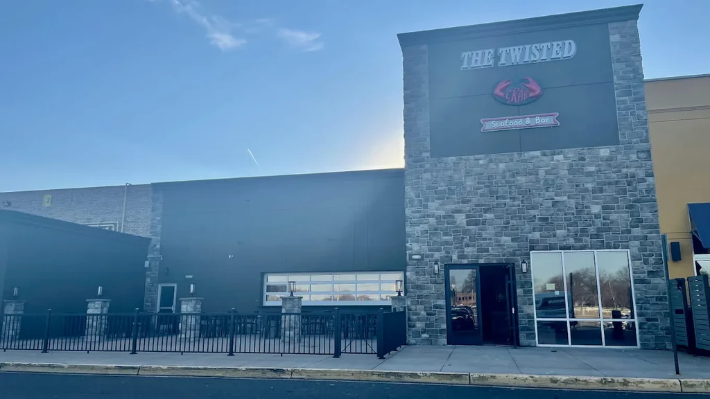 Modern "The Twisted Crab" restaurant exterior with stone facade and outdoor patio.