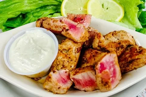 Seared rare tuna, creamy dipping sauce, lettuce, and lemon slices.