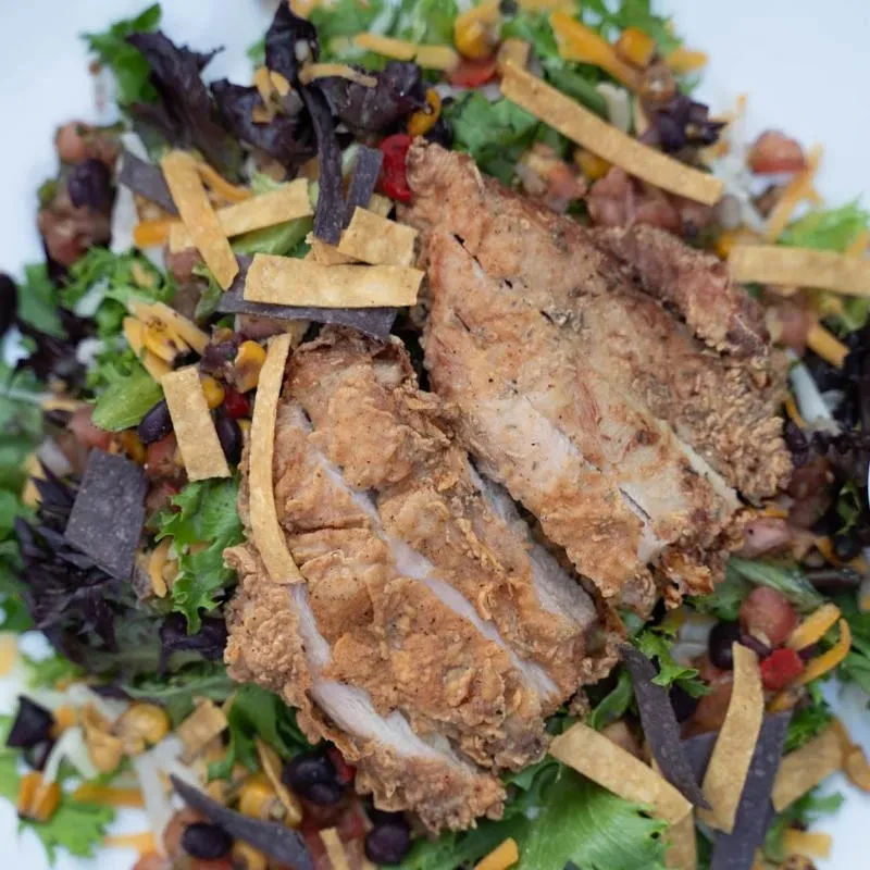 Fried chicken salad with mixed greens, corn, beans, cheese, and tortilla strips.