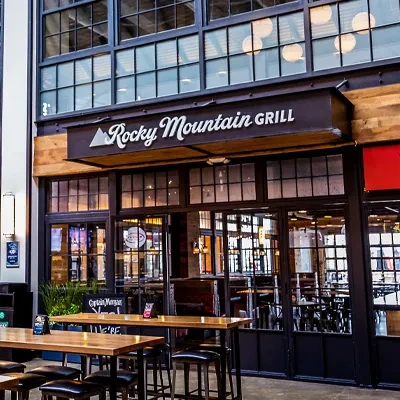 Modern industrial Rocky Mountain Grill facade with large windows, outdoor dining.