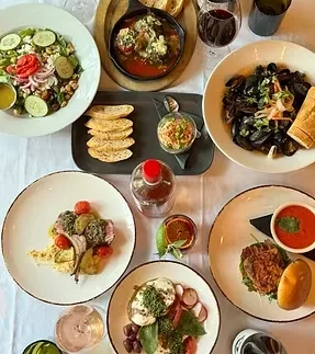 Overhead view of a dining table filled with diverse food and drinks.