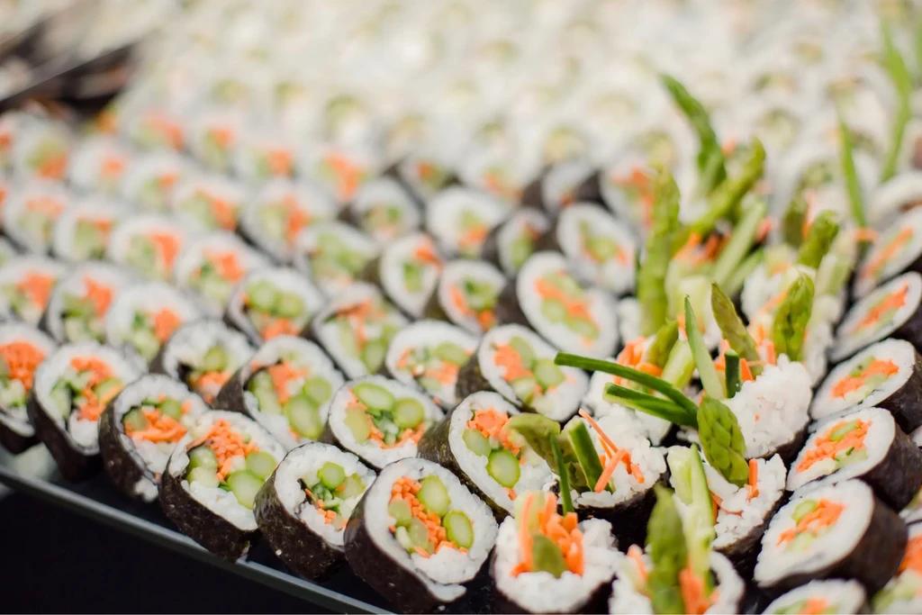 Close-up of assorted vegetable maki sushi rolls on a dark platter.