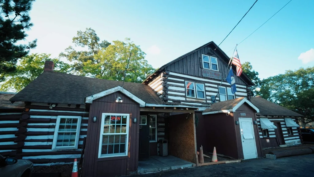 Log cabin-style White Oak Lodge building with "OPEN" sign and flags.