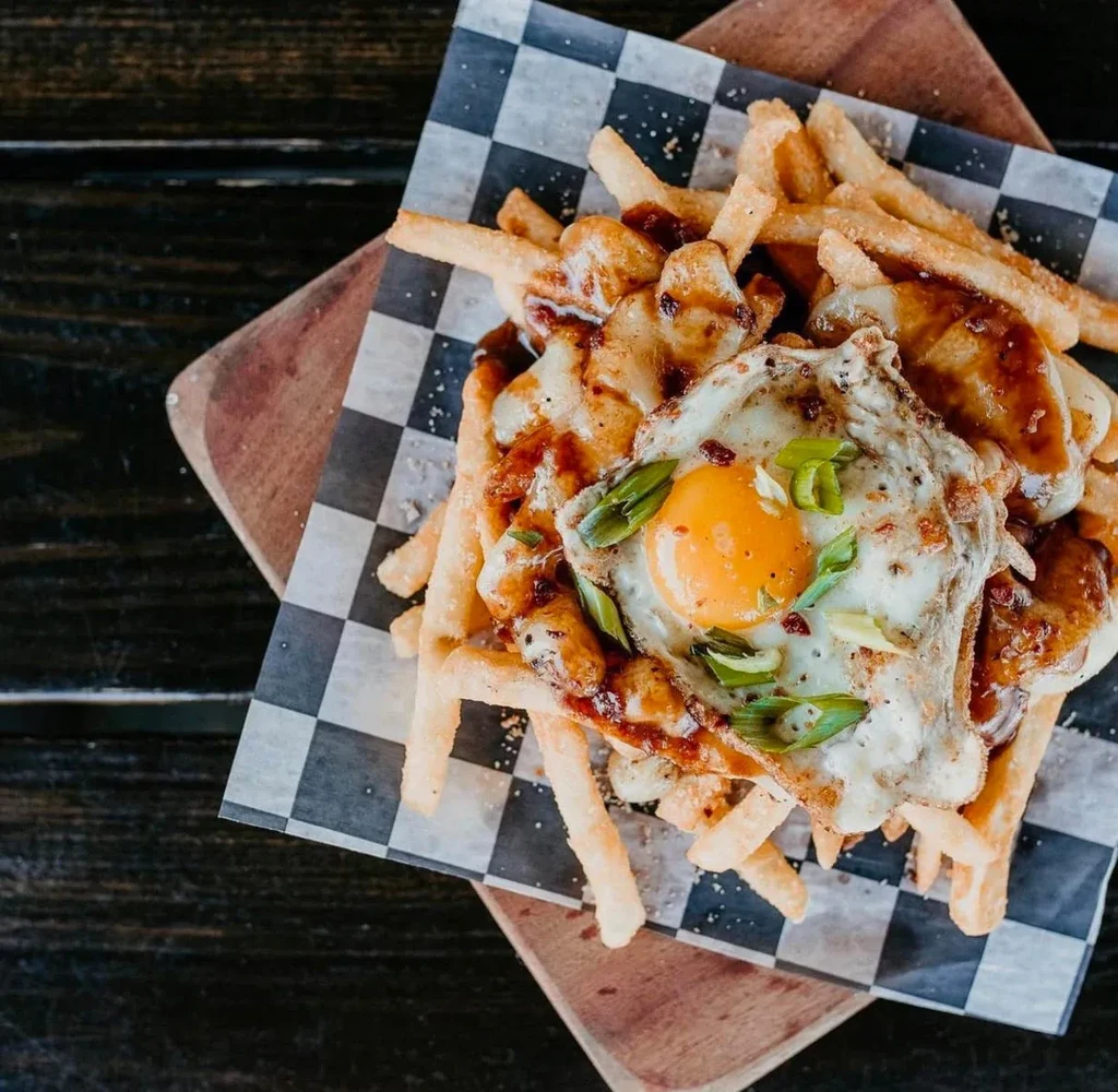 Poutine: fries, melted cheese, gravy, fried egg, green onions.