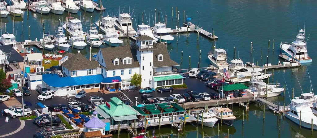 Vibrant aerial view of Rudee's waterfront restaurants and a busy marina.