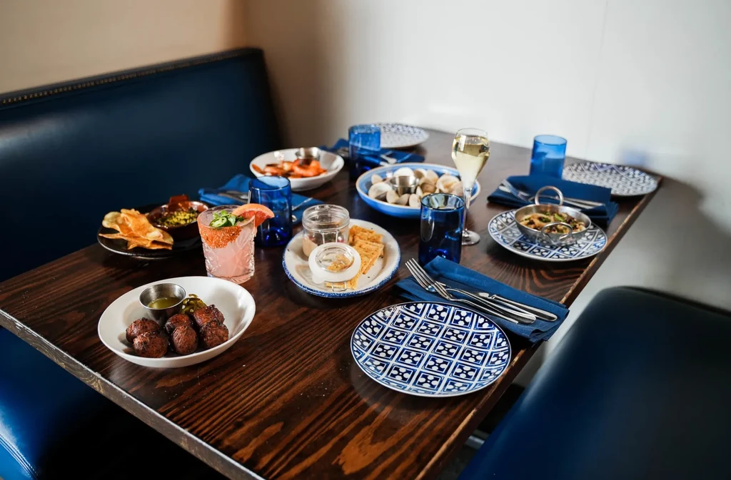 Restaurant table with various food and drinks, blue patterned tableware.