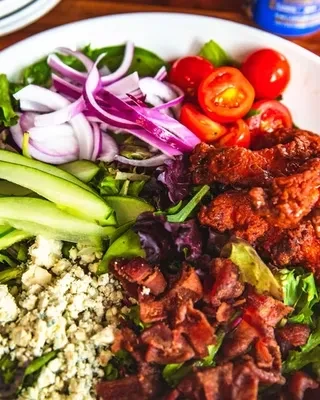 Salad with fried chicken, vegetables, blue cheese, and bacon.