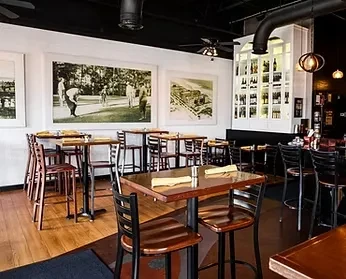 Empty modern restaurant interior with dining tables and a bar.