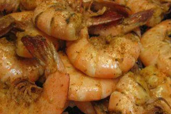 Pile of glossy, vibrant, seasoned orange-pink cooked shrimp.