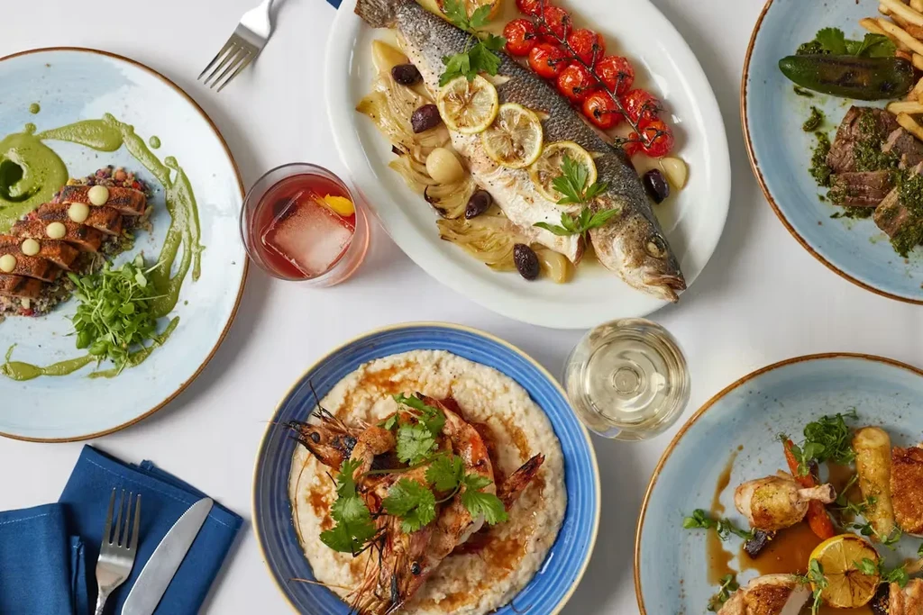 Overhead view of a table with diverse, well-prepared dishes and drinks.