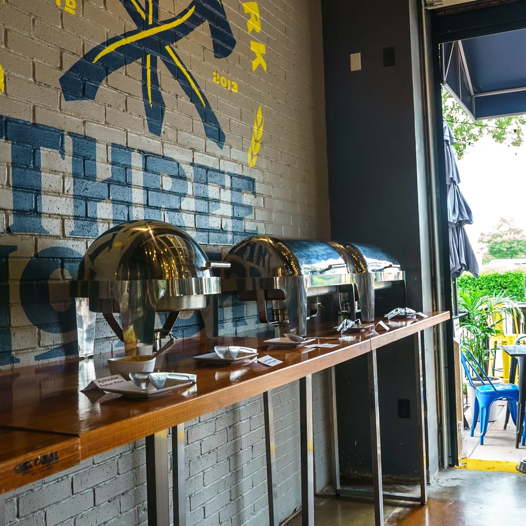 Chafing dishes on counter, painted brick wall, and outdoor patio.