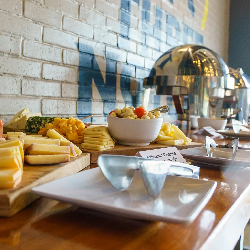 Assortment of cheeses, charcuterie, and Caprese salad on a buffet table.
