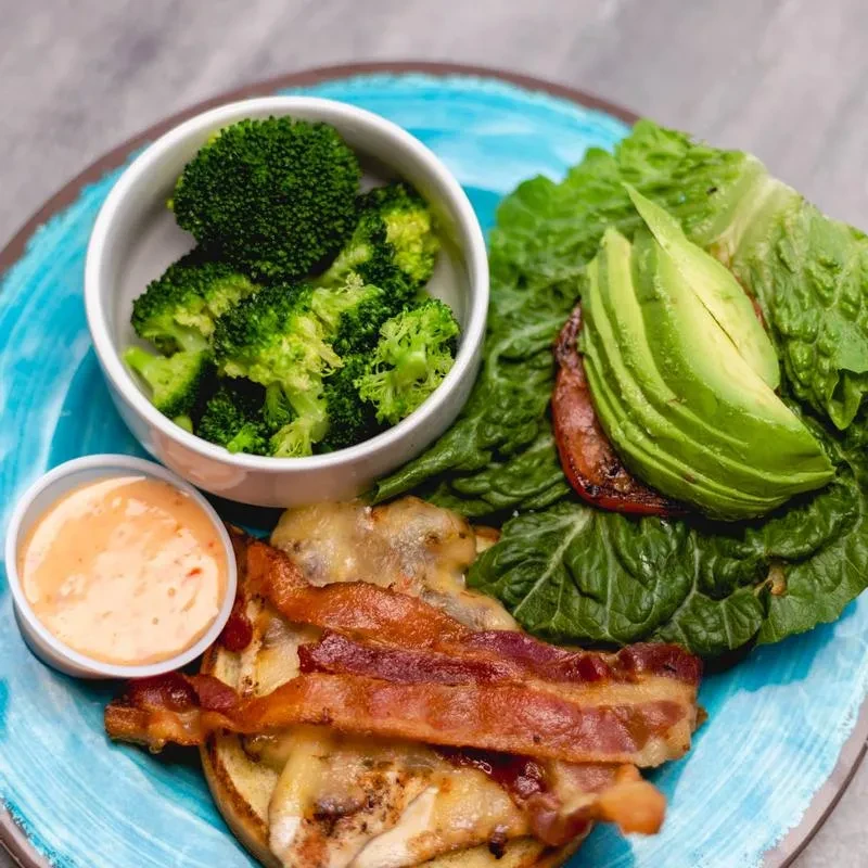 Grilled chicken, bacon, avocado salad, broccoli, and dipping sauce.