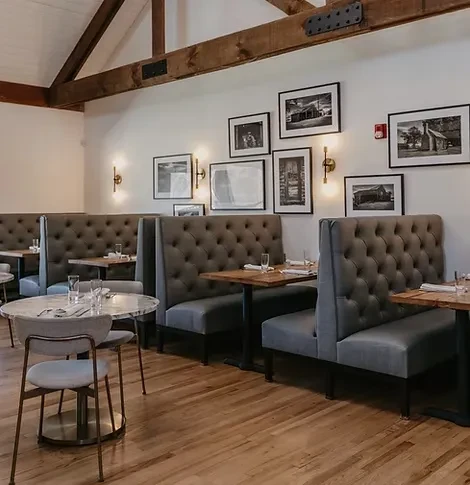 Empty modern rustic restaurant dining room with exposed beams and booths.