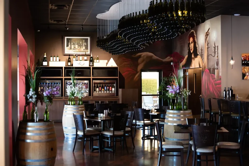 Upscale wine bar with bottle chandelier, wine displays, and artistic murals.