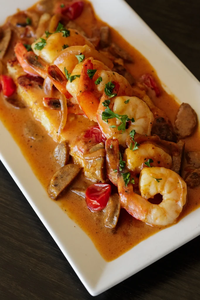Cooked shrimp, sausage, and tomatoes in creamy sauce with parsley.