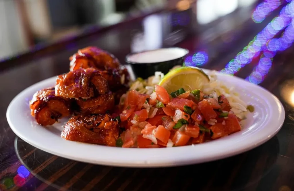 Glazed ribs or wings with pico de gallo, shredded topping, and lime.