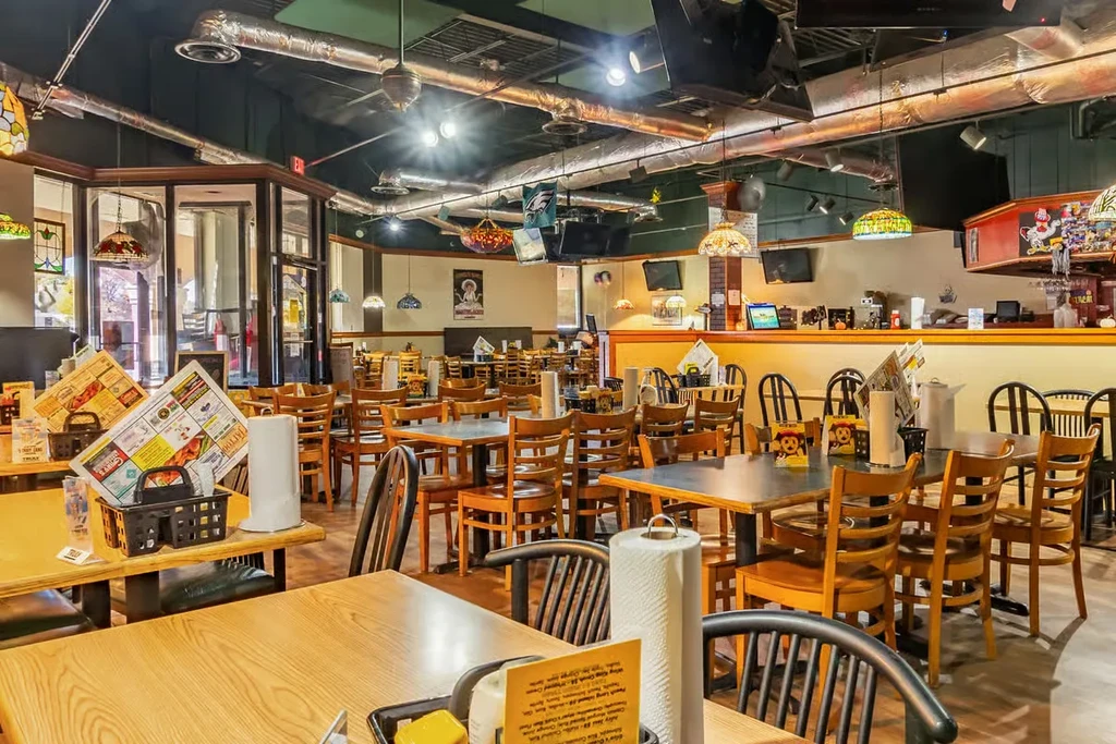 Empty casual restaurant dining room with a bar and Eagles flag.