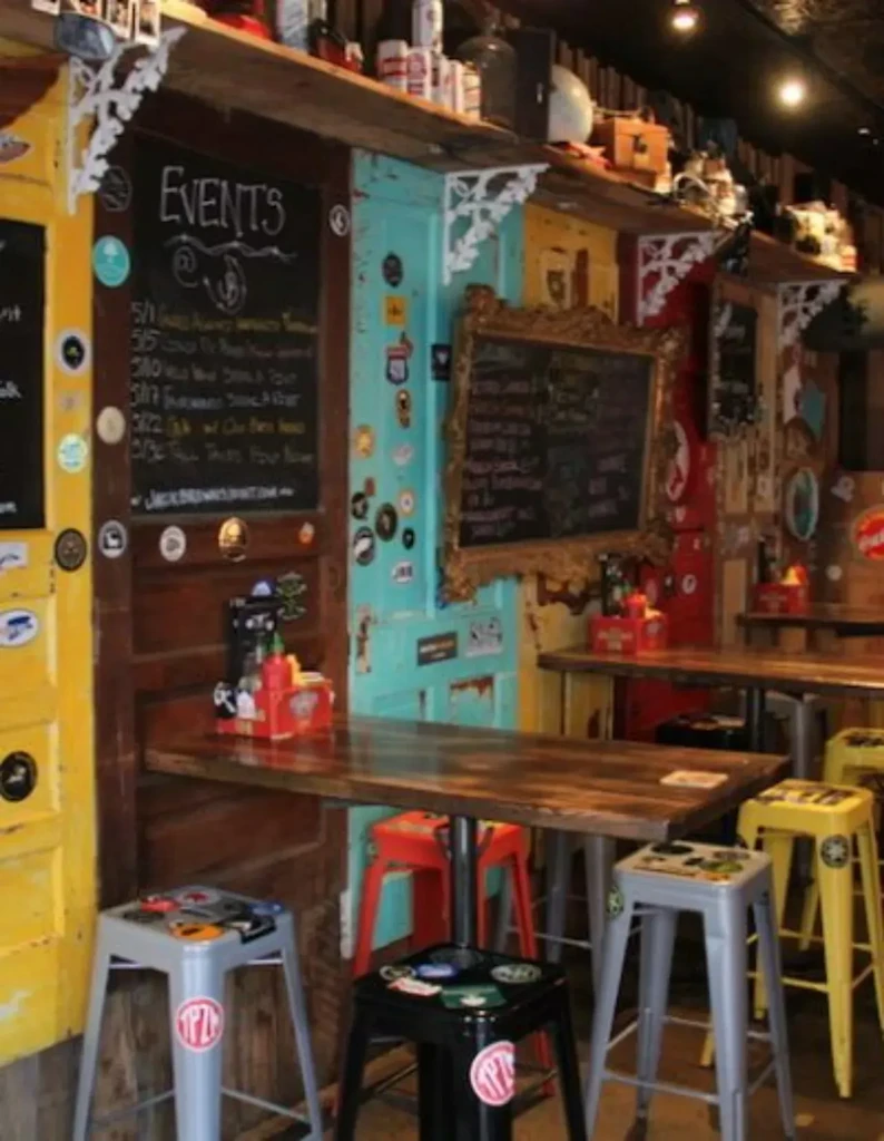 Eclectic bar interior with colorful bar stools and mismatched door walls.